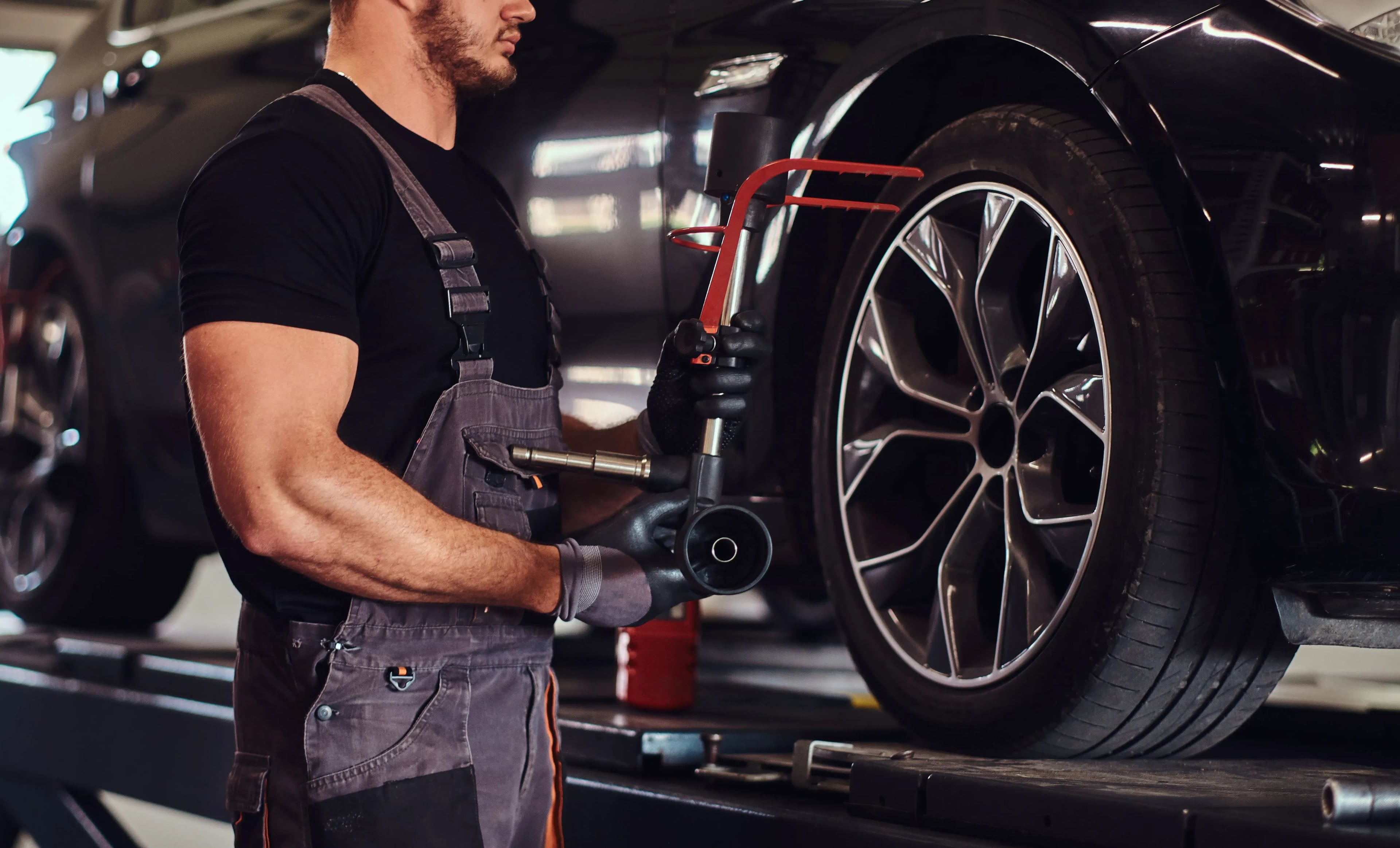 muscular man fixing car wheel
